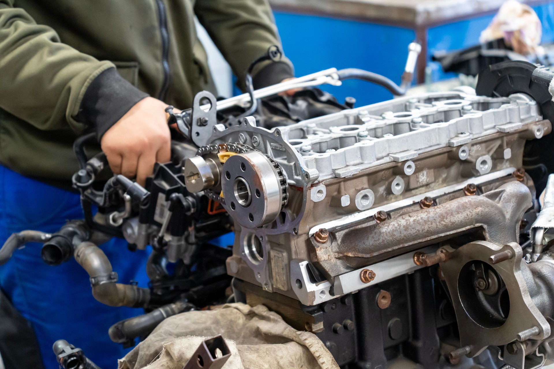 Auto mechanics assembling a disassembled car engine in a workshop